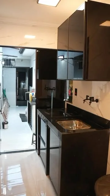 Área de serviço com bancada de granito e armários de vidro preto
