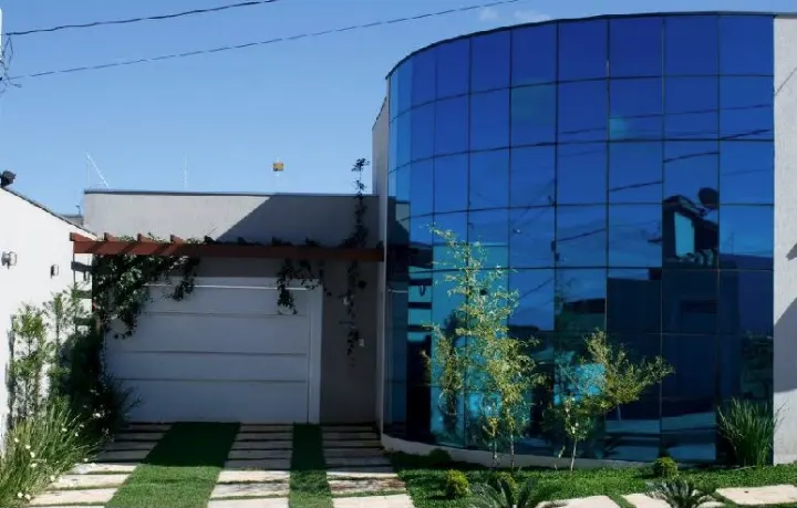 Casa com fachada curva em pele de vidro azul
