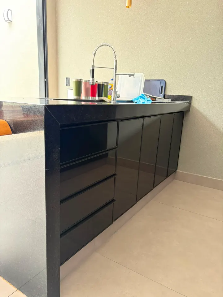 Bancada de cozinha com armários de vidro preto