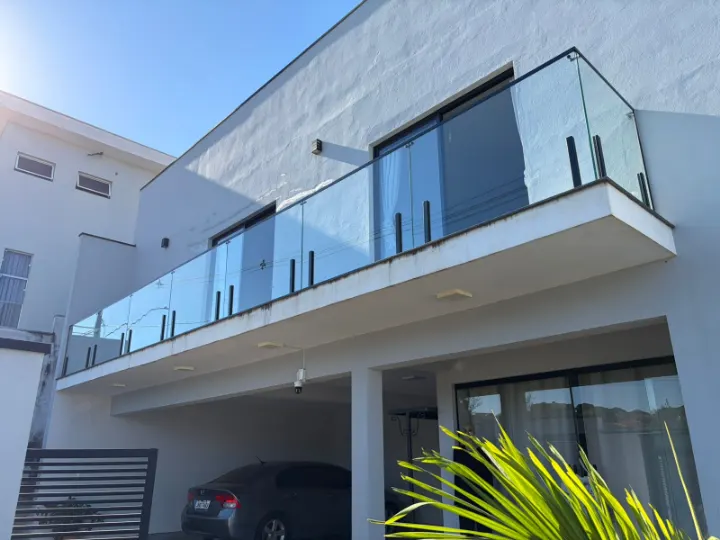 Guarda-corpo de vidro temperado com colunas pretas na sacada de um sobrado