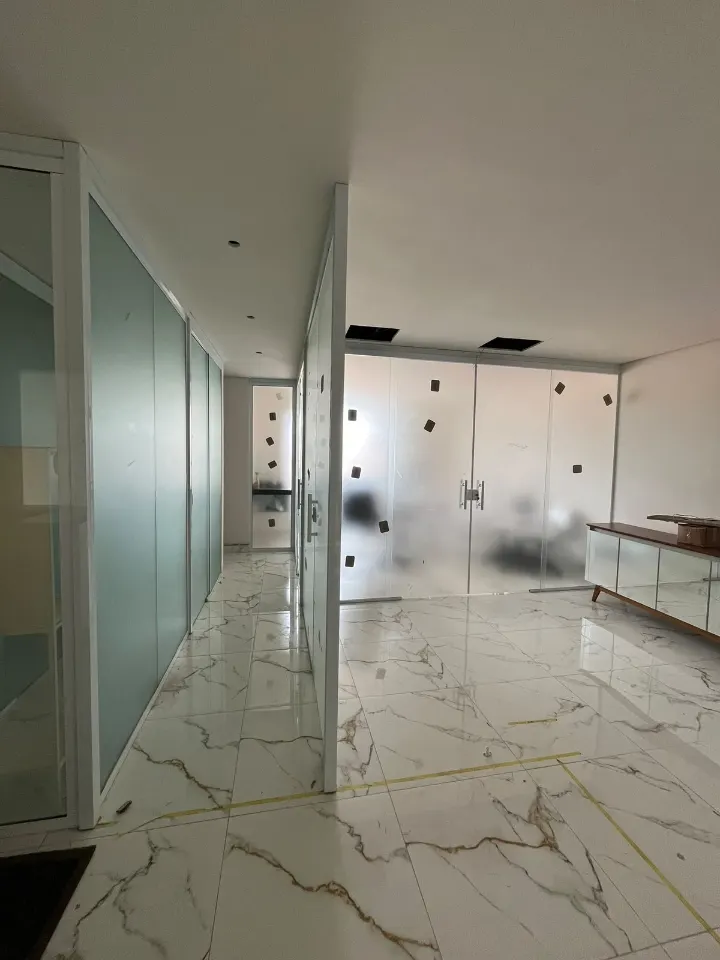 Corredor com divisórias de vidro fosco e porta de vidro
